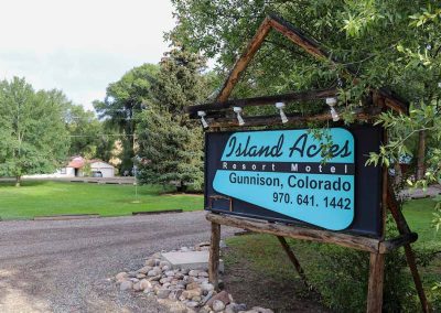 Photo of Island Acres Resort Motel sign with information about Island Acres like the town and phone number. Island Acres Resort Motel Gunnison Colorado