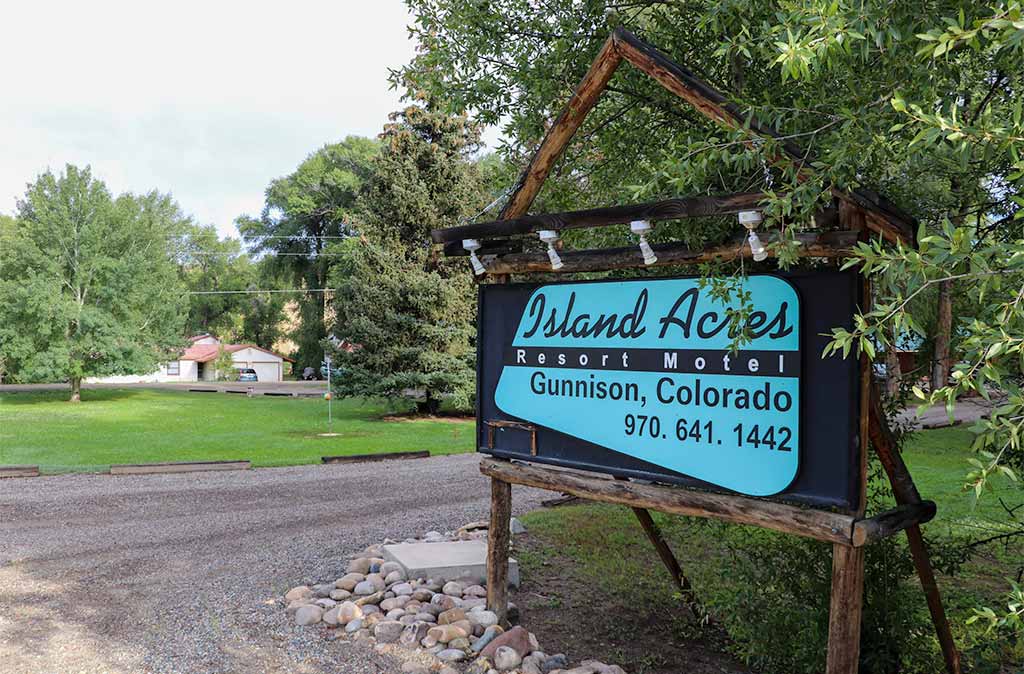 Photo of Island Acres Resort Motel sign with information about Island Acres like the town and phone number. Island Acres Resort Motel Gunnison Colorado