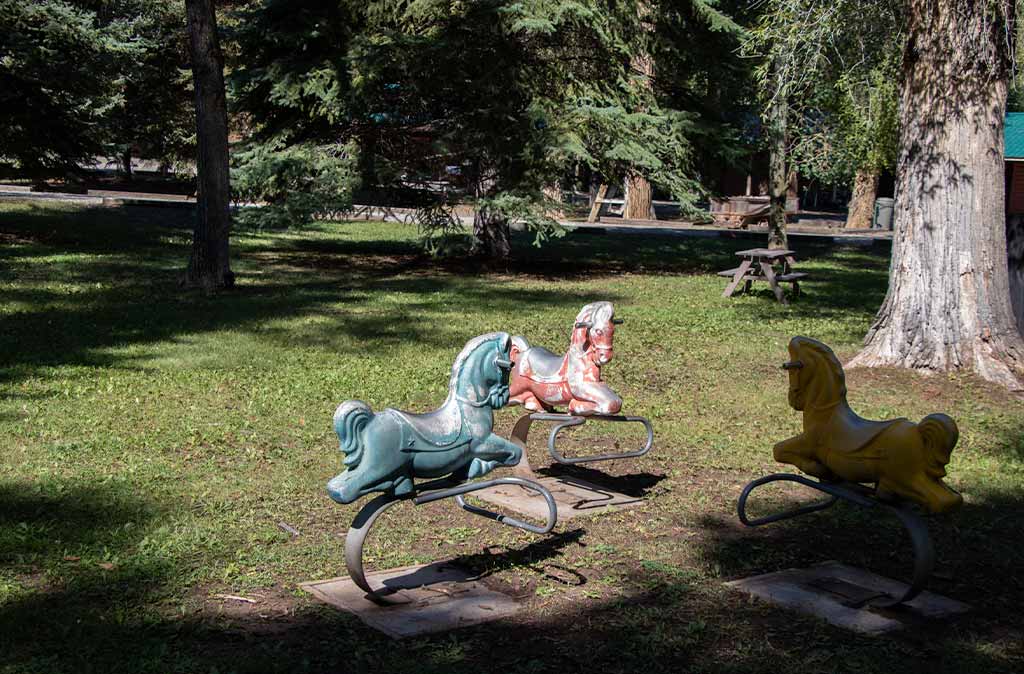 Photo of three horse spring riders in the large park at Island Acres Resort Motel.