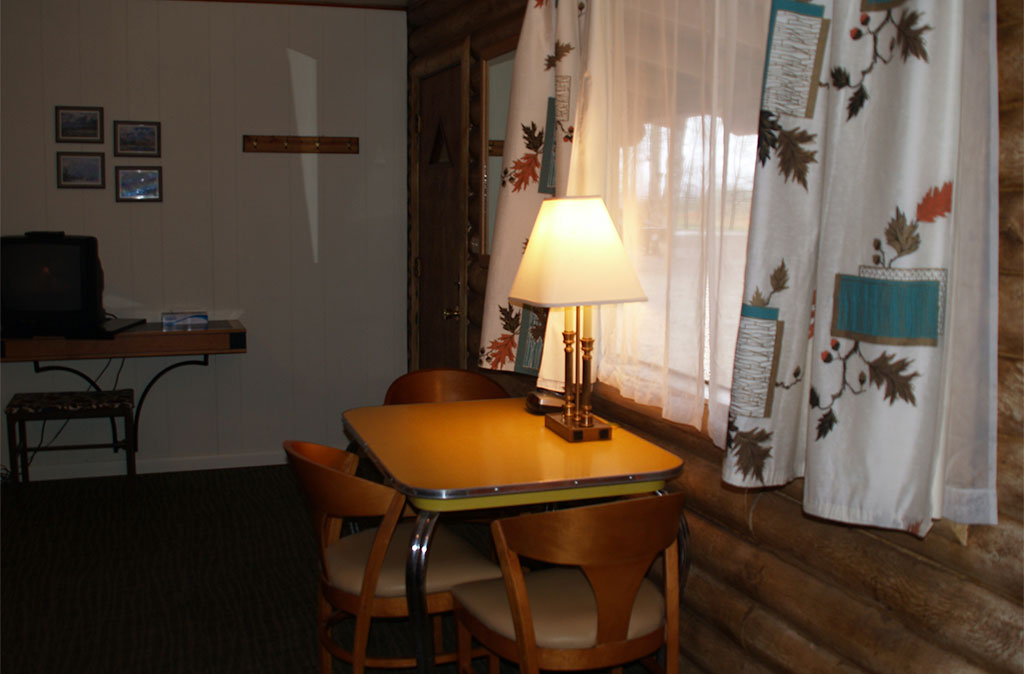 Photo of Queen Studio Unit at Island Acres Resort Motel showing mid-century dining table and vintage curtains.