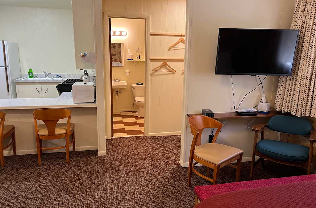 Photo of Deluxe Studio Unit at Island Acres Resort Motel showing kitchen, bathroom, closet, and wall-mounted flat screen TV.